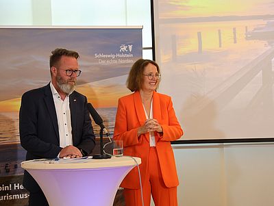 Dr. Bettina Bunge und Claus Ruhe Madsen stehen nebeneinander an einem Stehtisch.