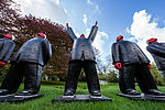 Menschenähnliche Figuren stehen draußen mit dem Blick in Richtung Himmel auf der Nordart in Büdelsdorf. 