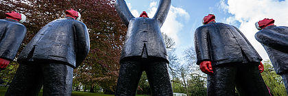 Menschenähnliche Figuren stehen draußen mit dem Blick in Richtung Himmel auf der Nordart in Büdelsdorf.  - zum Artikel 'Kultur pur im echten Norden'