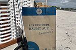 Müllgreifer und Papierbeutel im Sandstrand von Eckernförde.