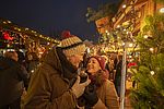 Ein Mann und eine Frau stehen zusammen auf dem beleuchteten Weihnachtsmarkt in Büsum. 