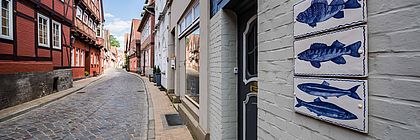 Die wunderschöne Elbstraße in Lauenburg verzaubert mit ihren bunten Fachwerkhäusern, Galerien, Ateliers und Manufakturen. - zum Artikel 'Besondere Einkaufserlebnisse bei einer Manufakt(o)ur  durch Schleswig-Holstein'