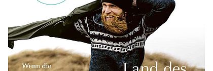Der echte Norden - Magazin Cover mit einem Mann, der sich bei Wind am Strand eine Jacke anzieht.  - zum Artikel 'Lust auf Schleswig-Holstein: Neues Magazin mit Reportagen und Geschichten aus dem echten Norden erschienen'