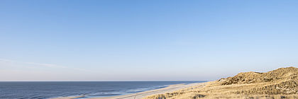 Eine Düne auf Sylt mit der Nordsee im Hintergrund.  - zum Artikel 'Schleswig-Holstein-Tourismus 2020:  Ein Halbjahr der Extreme'