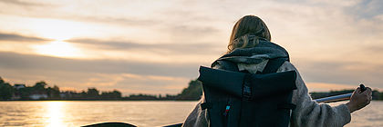 Kampagnen-Foto mit dem Schriftzug "echt nordiSH". Eine Frau paddelt in einem Kanu auf dem See.  - zum Artikel 'Echt nordiSH: TA.SH startet neue Kampagne für Nebensaison'