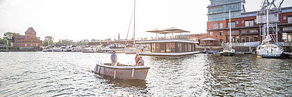 Elektroboot der Firma Boat Now fährt im im Lübecker Hafen bei Sonnenschein.  - zum Artikel 'Schleswig-Holstein entdecken: Ideen für Tagesausflüge und Wochenendabenteuer'