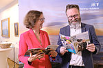 Dr. Bettina Bunge und Claus Ruhe Madsen halten lachend das Magazin "Ganz weit oben" in der Hand. 