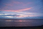 Das Wattenmeer in Schleswig-Holstein. Der Himmel ist rosa gefärbt.