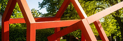 Eine Kunstinstallation auf der NordArt n Rot erinnert an das Gerüst eines Hauses.  - zum Artikel 'Kunstvolles in Schleswig-Holstein'