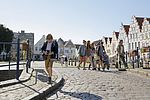 Schulkinder laufen durch Friedrichstadt. Im Hintergrund stehen Giebelhäuser.