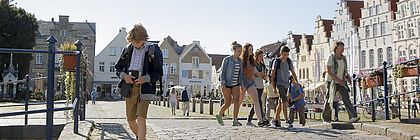 Schulkinder laufen durch Friedrichstadt. Im Hintergrund stehen Giebelhäuser. - zum Artikel 'Film ab!'
