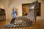 Zu sehen ist ein überdimensionierter hochhackiger Schuh als Ausstellungsstück in einem Museum. 
